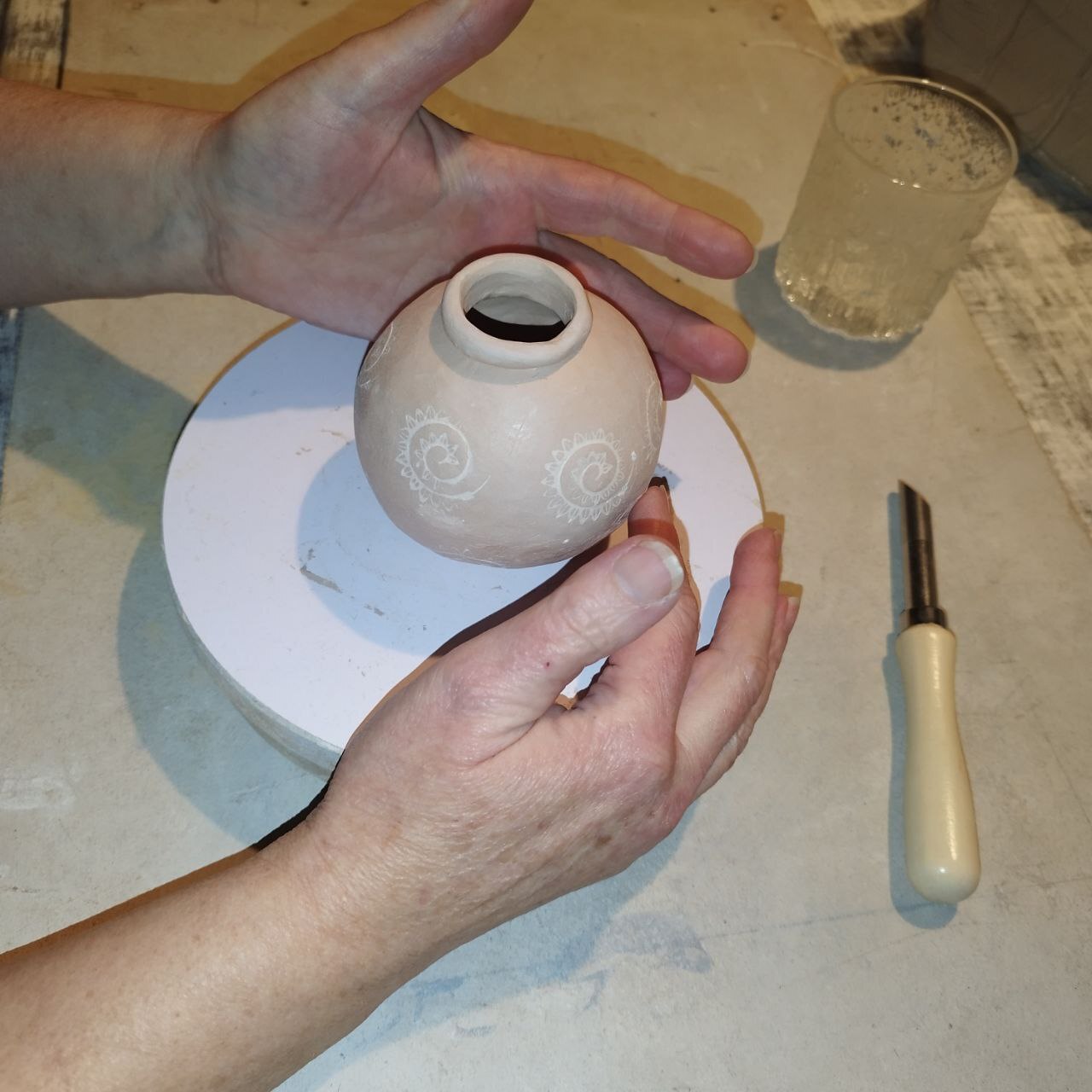 Hände formen einen Krug aus Ton